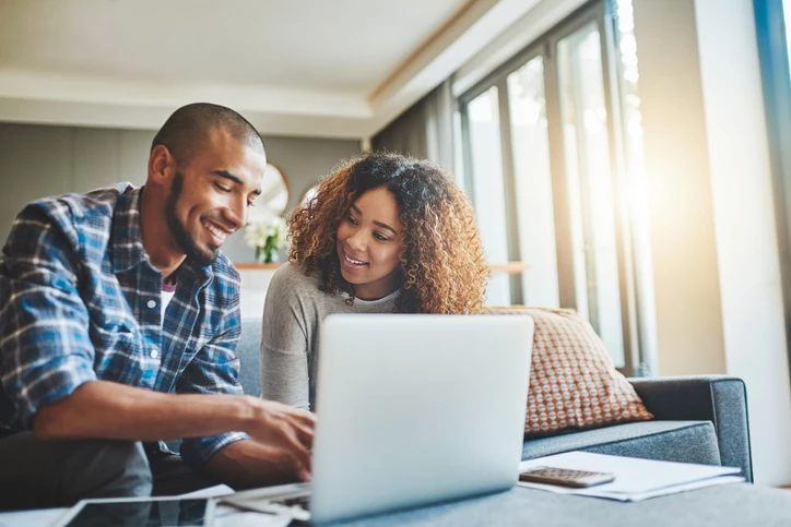 Couple looking at laptop and smiling