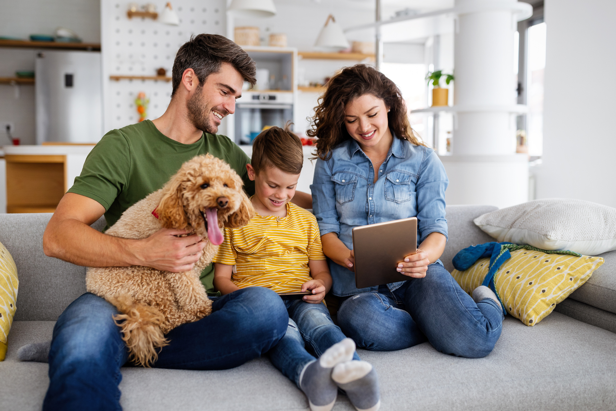 Happy family with dog looking over list on iPad