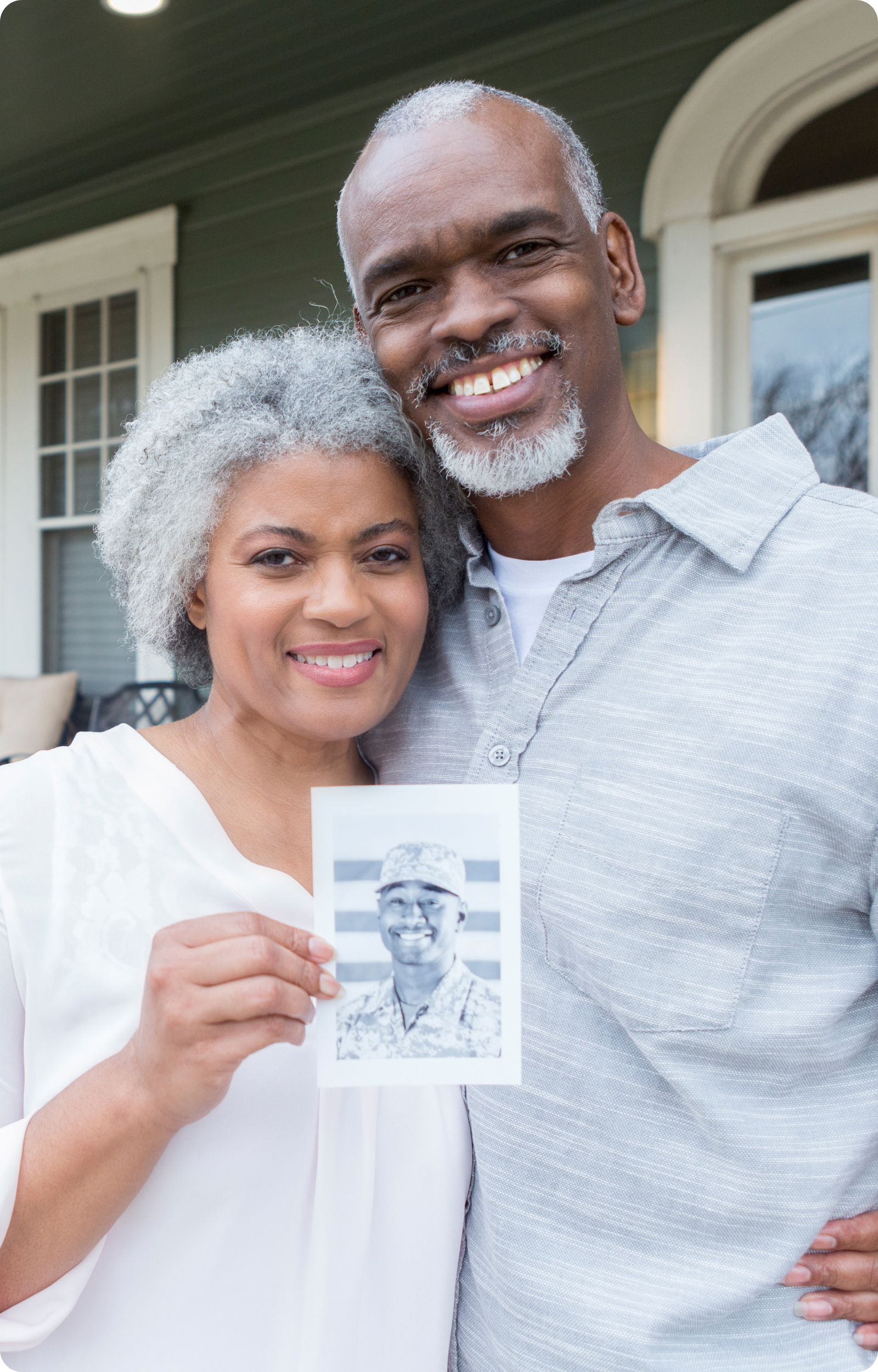 couple holding up an image of their veteran son